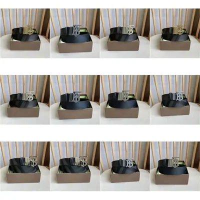 Monogram leather belts with polished buckles laid out in three rows