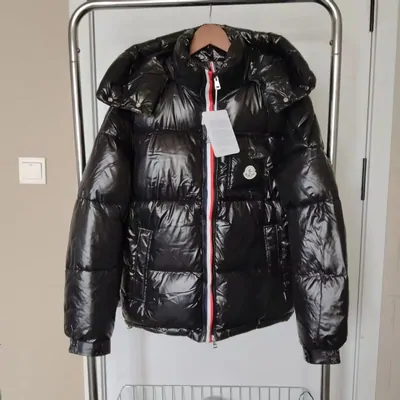 Glossy black puffer jacket on a hanger with its tags still attached